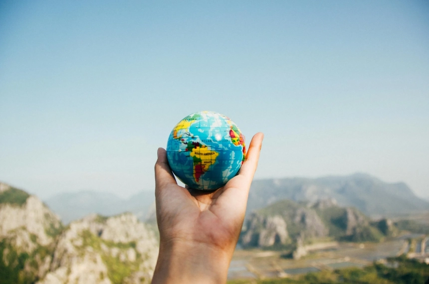 A person holding a small globe in their hand.