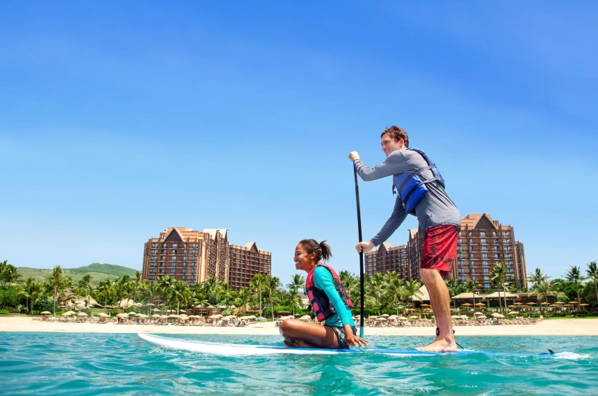 A man and woman paddle boarding in the ocean.