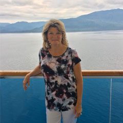 A woman standing on the deck of a cruise ship.