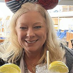 A woman with a mouse ear on her head holding two lemons.