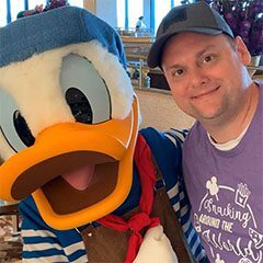 A man posing with a goofy looking duck.