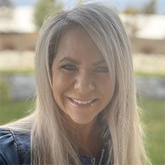 A woman with long white hair smiling for the camera.