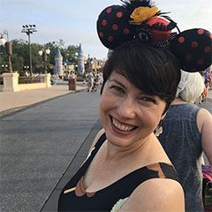 A woman with minnie mouse ears on her head.