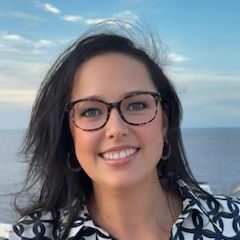 A woman with glasses smiling for the camera.